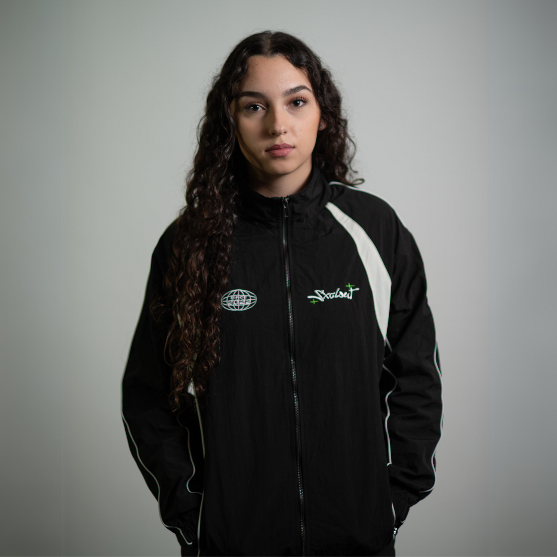 Woman wearing black Vision Trackjacket, streetwear nylon jacket by Chasedvision.