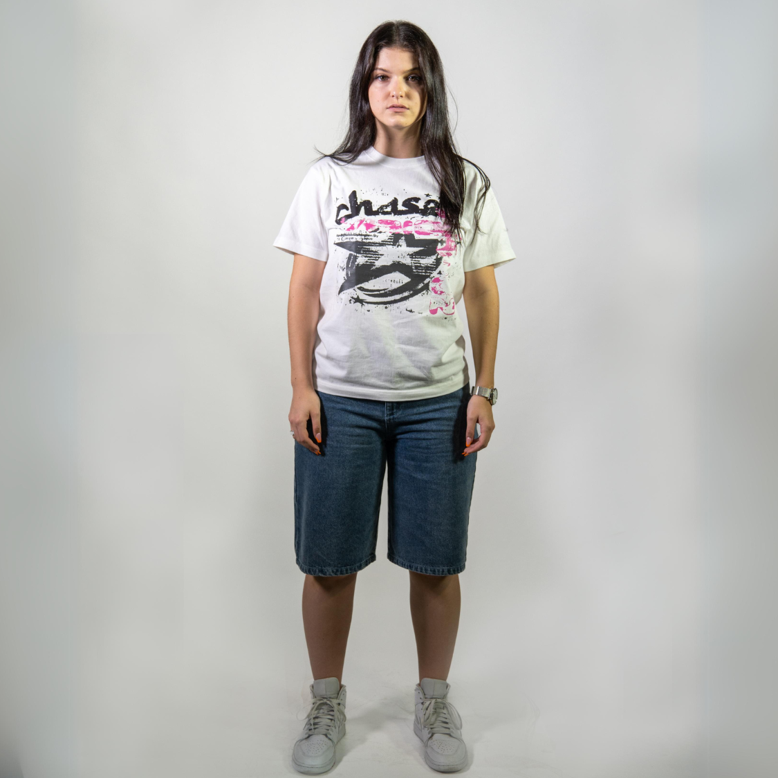 Woman wearing high quality blue washed jorts with attached keychain and a graphic t-shirt from Chasedvision, showcasing perfect fit and details.