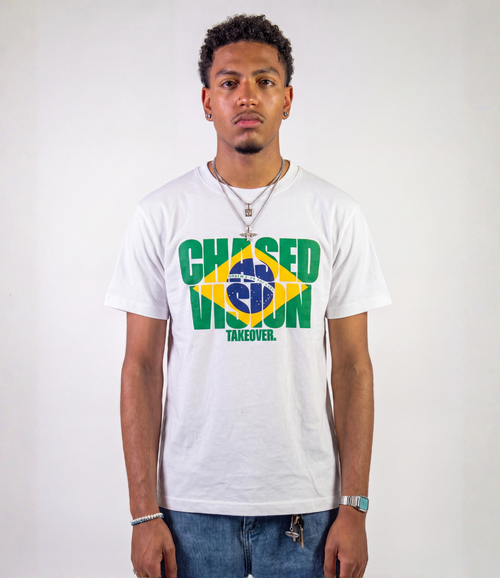 A male model wearing the white brazil worldcup tee from chasedvision with a "chasedvision takeover." design