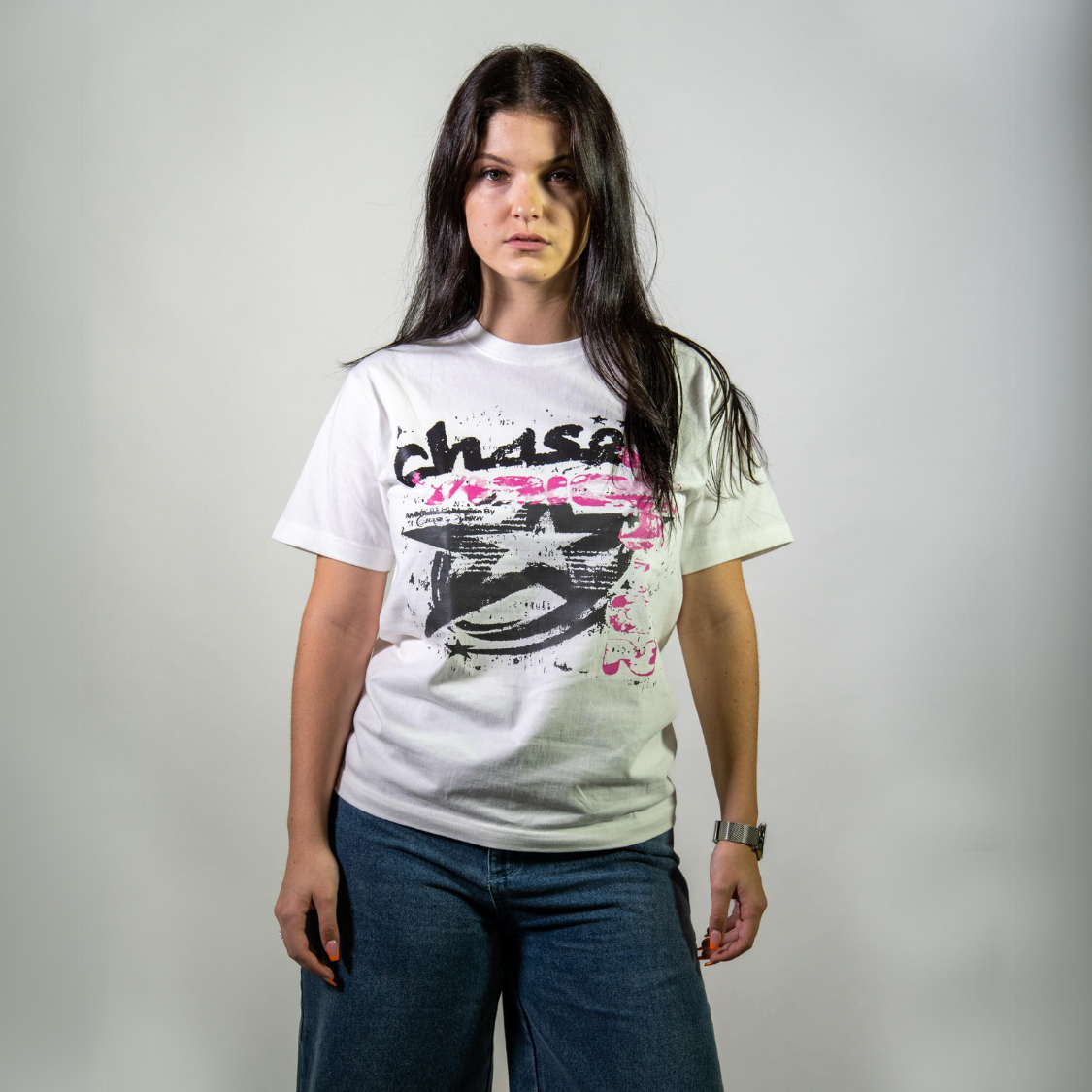 Woman wearing a Chasedvision oversized cotton tee with pink design, showcasing perfect fit and high-quality streetwear style.