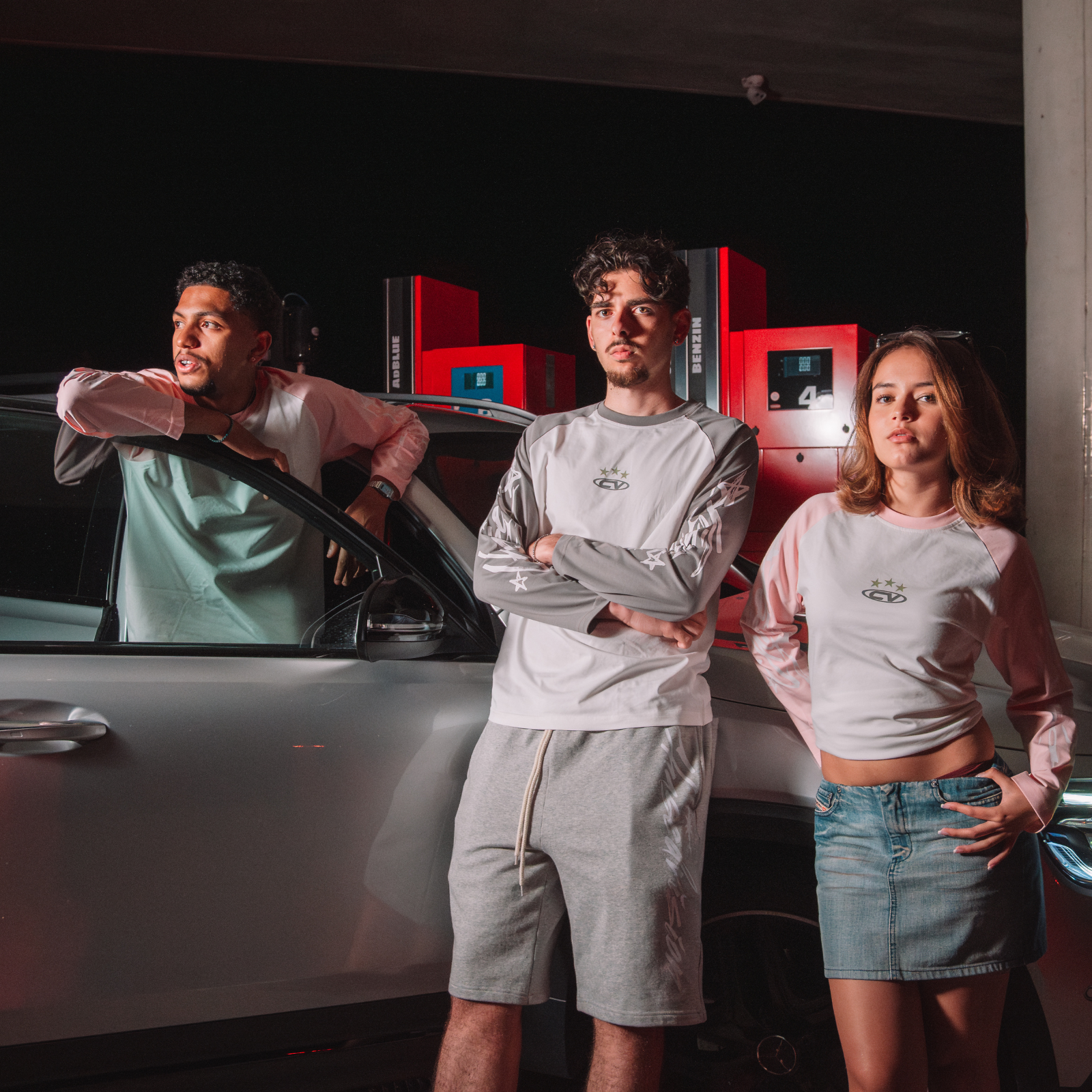 Three models showcasing grey longsleeve shirts styled with shorts and skirts, perfect summer fashion.